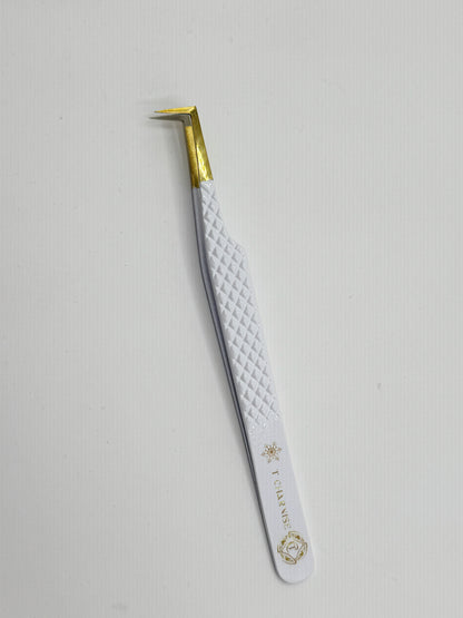 Eyebrow tweezer with white handle and gold accents on a light gray background